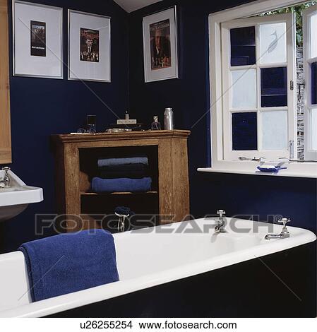 Blue+white chequerboard stained glass windows above freestanding rolltop bath in dark blue bathroom View Large Photo Image Picture - Blue+white chequerboard stained glass windows above freestanding rolltop bath in dark blue bathroom. Fotosearch