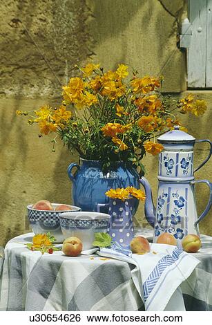 Blue+white cloth and pots on table in front of old stone wall in country garden in summer View Large Photo Image Stock Photograph - Blue+white cloth and pots on table in front of old stone wall in country garden in summer. Fotosearch