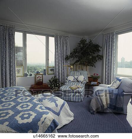 Blue+white quilts on bed and chest in bedroom with blue striped chaiselongue and blue carpet View Large Photo Image Stock Image - Blue+white quilts on bed and chest in bedroom with blue striped chaiselongue and blue carpet . Fotosearch