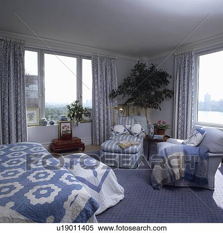 Blue+white quilts on bed and chest in bedroom with blue striped chaiselongue and blue carpet View Large Photo Image Stock Photography - Blue+white quilts on bed and chest in bedroom with blue striped chaiselongue and blue carpet . Fotosearch