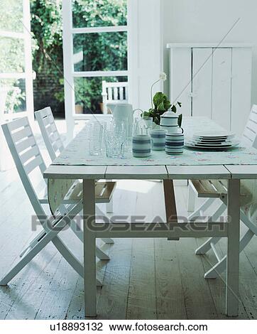 Blue+white striped cups with glass jug and glasses on white wooden table with matching chairs on white wood flooring View Large Photo Image Stock Image - Blue+white striped cups with glass jug and glasses on white wooden table with matching chairs on white wood flooring. Fotosearch