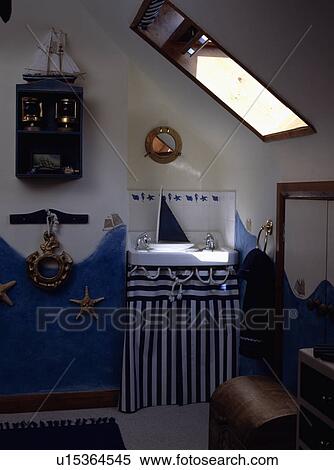 Blue+white striped curtain below basin in nautical themed attic bathroom with painted blue wave on wall View Large Photo Image Stock Photography - Blue+white striped curtain below basin in nautical themed attic bathroom with painted blue wave on wall. Fotosearch