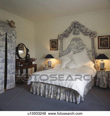 Blue+white Toile de Jouy drapes and bed with matching vallance and tented wardrobe in traditional bedroom View Large Photo Image Stock Photo - Blue+white Toile de Jouy drapes and bed with matching vallance and tented wardrobe in traditional bedroom. Fotosearch
