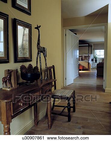 Bowl of pinecones and carved wooden giraffe on antique wooden console table on landing with wooden floorboards View Large Photo Image Stock Image - Bowl of pinecones and carved wooden giraffe on antique wooden console table on landing with wooden floorboards. Fotosearch