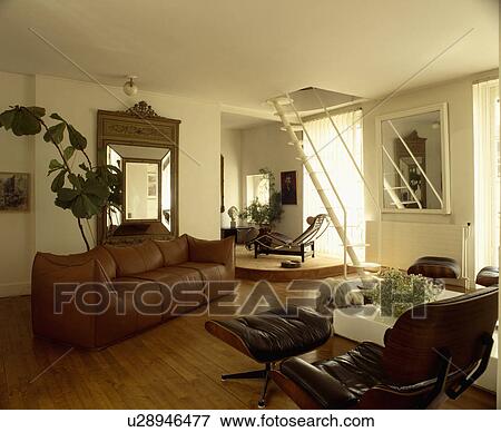 Brown leather sofa and Charles Eames chaiselongue in modern living room View Large Photo Image Stock Photo - Brown leather sofa and Charles Eames chaiselongue in modern living room. Fotosearch