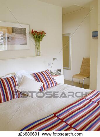 Candystriped cushions and matching throw with white linen on bed in modern white bedroom View Large Photo Image Stock Image - Candystriped cushions and matching throw with white linen on bed in modern white bedroom. Fotosearch