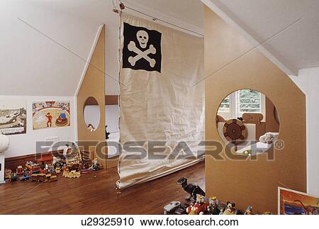 Stock Image - Canvas room divider with scull+crossbones motif in children's bedroom with cut-out circles in plywood bed ends . Fotosearch
