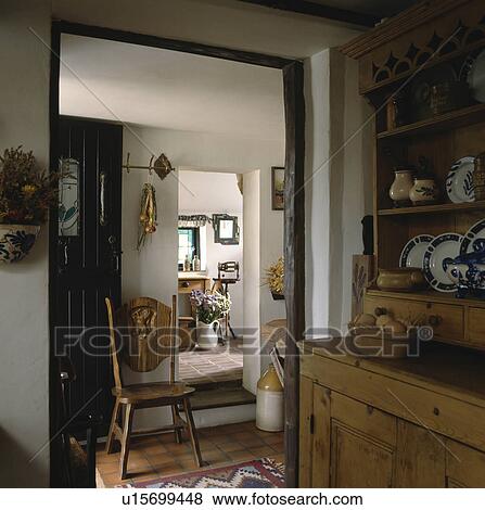 Carved wooden chair in doorway of cottage kitchen with pine dresser View Large Photo Image Stock Photo - Carved wooden chair in doorway of cottage kitchen with pine dresser. Fotosearch