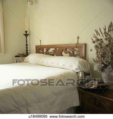 Carved wooden headboard on bed in neutral bedroom with cream bed linen View Large Photo Image Stock Photography - Carved wooden headboard on bed in neutral bedroom with cream bed linen. Fotosearch