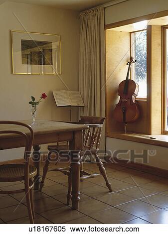 Cello on windowsill in diningroom with tiled floor and pine table and chairs View Large Photo Image Stock Photography - Cello on windowsill in diningroom with tiled floor and pine table and chairs. Fotosearch