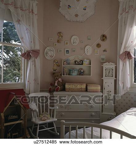 Child's white rocking chair and stencilled white chest of drawers in pink bedroom with white curtains and pink tiebacks View Large Photo Image Stock Photography - Child's white rocking chair and stencilled white chest of drawers in pink bedroom with white curtains and pink tiebacks. Fotosearch