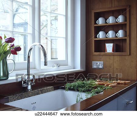 Chrome mixer tap and white ceramic sink underset in wooden worktop below white cups on small alcove shelves View Large Photo Image Stock Photo - Chrome mixer tap and white ceramic sink underset in wooden worktop below white cups on small alcove shelves. Fotosearch