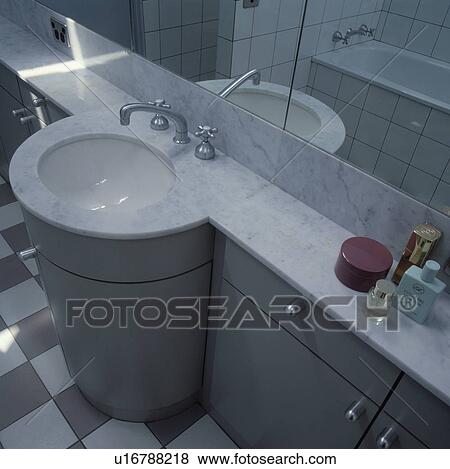 Stock Photo - Circular white basin underset in marble-topped fitted grey vanity unit. Fotosearch
