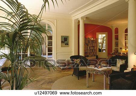 Stock Photo - Classical pillars in living room with tall houseplant. Fotosearch