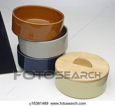 Stock Photo - Close-up of 4 stacking pottery dishes with wooden lids. Fotosearch