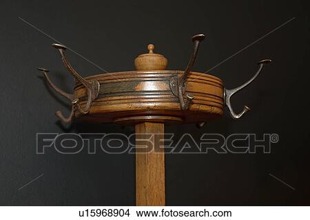 Picture - Close-up of antique wooden hat-stand with brass hooks. Fotosearch