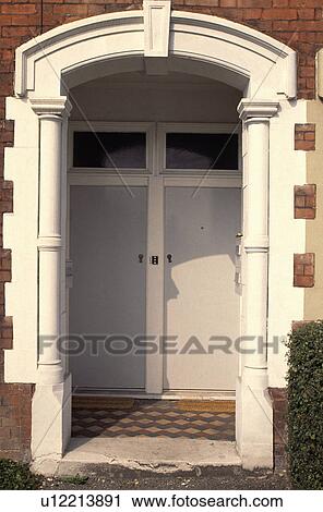 Stock Image - Close-up of arched Edwardian porch and white doors. Fotosearch