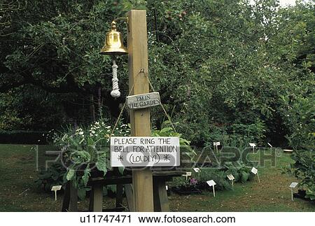 Stock Image - Close-up of bell on post in country garden. Fotosearch