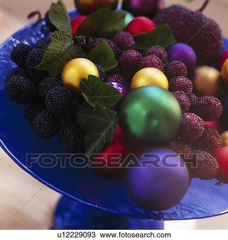 Close-up of blue glass bowl with faux fruit and primary coloured Christmas baubles View Large Photo Image Stock Image - Close-up of blue glass bowl with faux fruit and primary coloured Christmas baubles . Fotosearch