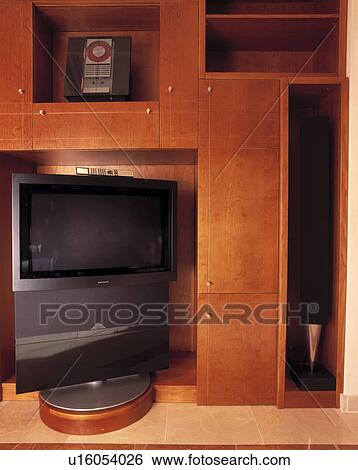 Stock Photograph - Close-up of CD player and flatscreen television in alcoves in modern cupboard. Fotosearch