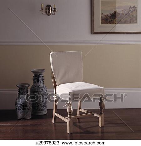 Close-up of chair with cream loosecover in neutral hall with wooden flooring View Large Photo Image Stock Image - Close-up of chair with cream loosecover in neutral hall with wooden flooring. Fotosearch
