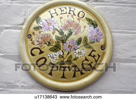 Stock Image - Close up of circular plaque with insribed cottage name. Fotosearch
