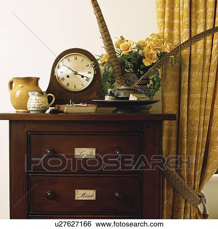 Stock Photograph - Close-up of clock on antique chest-of-drawers. Fotosearch