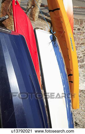 Stock Image - Close up of colourful upended boats. Fotosearch