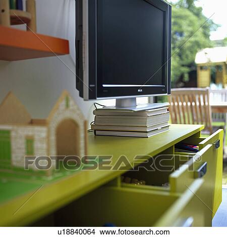 Close up of flatscreen television on lime green storage cupboard in modern playroom View Large Photo Image Picture - Close up of flatscreen television on lime green storage cupboard in modern playroom. Fotosearch