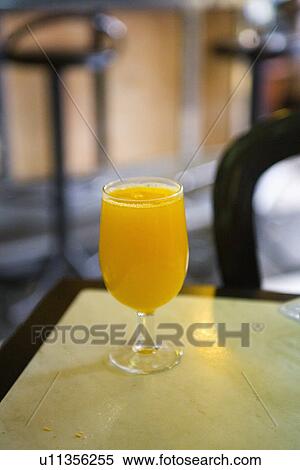 Close up of glass of orange juice on table View Large Photo Image Stock Photography - Close up of glass of orange juice on table. Fotosearch
