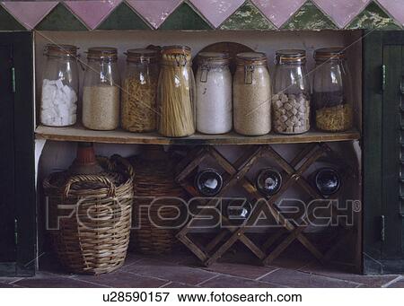 Stock Photo - Close-up of glass storage jars and baskets on rustic wooden shelves. Fotosearch