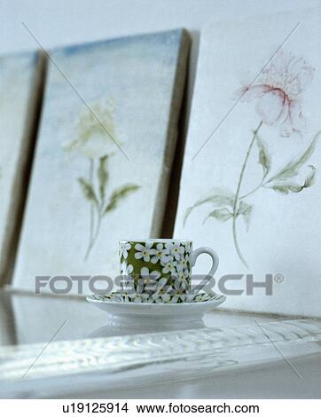Close-up of green+white floral teacup in front of floral pictures View Large Photo Image Picture - Close-up of green+white floral teacup in front of floral pictures. Fotosearch