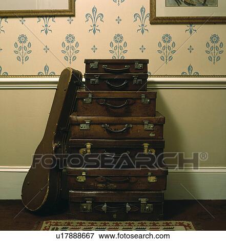 Close-up of guitar case leaning against pile of old brown leather suitcases View Large Photo Image Stock Photo - Close-up of guitar case leaning against pile of old brown leather suitcases. Fotosearch