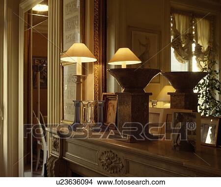 Close-up of lighted lamp on mantelpiece below mirror View Large Photo Image Picture - Close-up of lighted lamp on mantelpiece below mirror. Fotosearch