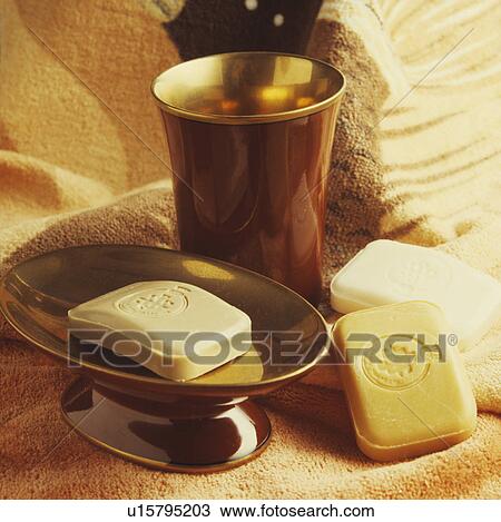 Stock Image - Close-up of metal beaker and soap in metal soapdish . Fotosearch