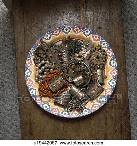 Stock Photo - Close-up of Moroccan and African jewellery on pottery dish. Fotosearch