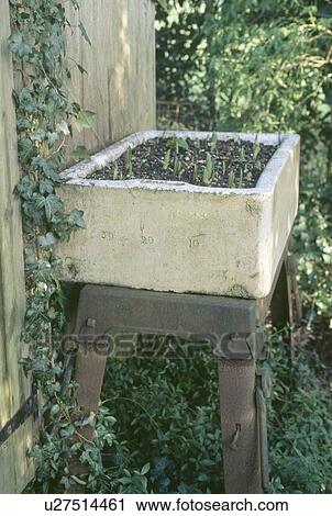 Stock Image - Close up of old recycled ceramic sink on metal table. Fotosearch