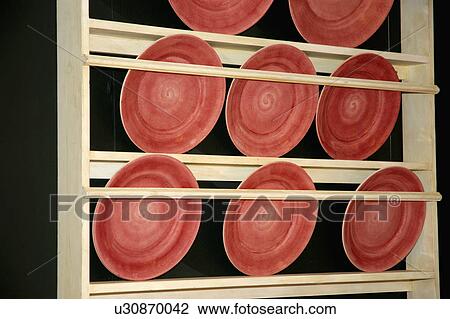 close-up of orange pottery plates on light wood plate-rack View Large Photo Image Stock Image - close-up of orange pottery plates on light wood plate-rack. Fotosearch
