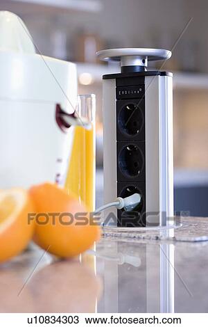 Stock Image - Close-up of oranges and juicer. Fotosearch