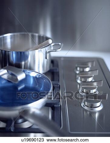 Close-up of pan and saucepan with blue lid on stainless steel hob with steel control knobs View Large Photo Image Stock Image - Close-up of pan and saucepan with blue lid on stainless steel hob with steel control knobs. Fotosearch