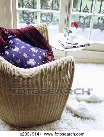 Stock Photo - Close-up of purple cushion on modern wicker armchair. Fotosearch