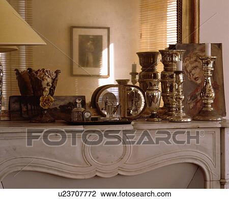 Close-up of silver candlesticks in front of mirror on marble mantelpiece View Large Photo Image Stock Image - Close-up of silver candlesticks in front of mirror on marble mantelpiece. Fotosearch