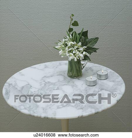 Stock Photo - Close-up of snowdrops in vase on marble table. Fotosearch