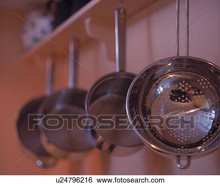 Stock Photograph - Close-up of stainless steel colander and saucepans. Fotosearch