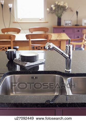 Stock Photo - Close-up of stainless steel mixer tap and double steel sinks. Fotosearch