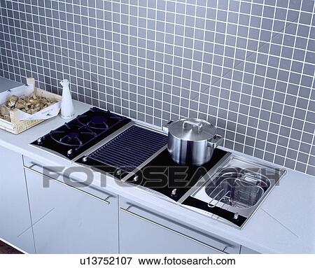 Close-up of stainless steel pan on triple fuel hob beside integral chip fryer View Large Photo Image Stock Photo - Close-up of stainless steel pan on triple fuel hob beside integral chip fryer . Fotosearch