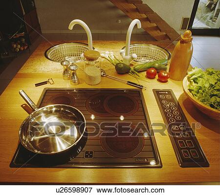 Close-up of stainless steel pan on halogen hob in wood worktop with double circular unset sinks View Large Photo Image Stock Photo - Close-up of stainless steel pan on halogen hob in wood worktop with double circular unset sinks. Fotosearch