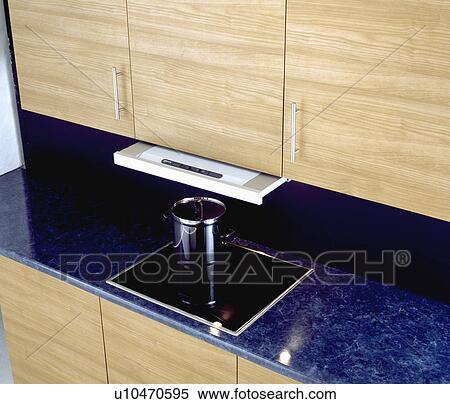 Close-up of stainless steel pan on small hob in kitchen worktop View Large Photo Image Stock Photography - Close-up of stainless steel pan on small hob in kitchen worktop . Fotosearch