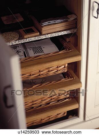 Stock Image - Close up of storage baskets on shelf unit. Fotosearch