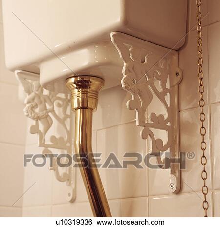 Stock Photograph - Close-up of Victorian-style toilet cistern with brass pipe. Fotosearch